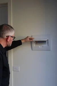 Building inspector examining electrical switchboard during Melbourne building and pest inspection
