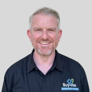 Philip Guildea, Director of Buy Wise Inspections, smiling in a branded company shirt.